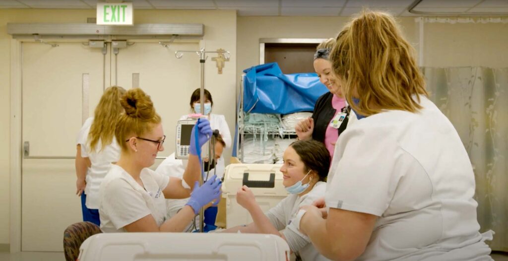 Nursing students adjusting medical equipment in group activity