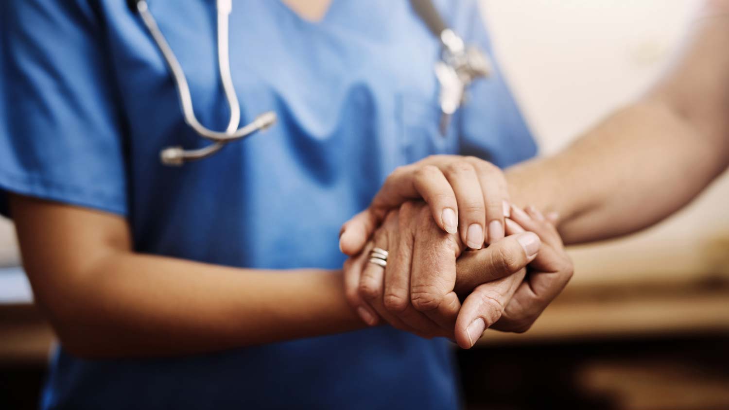 Nurse holding hands with patient